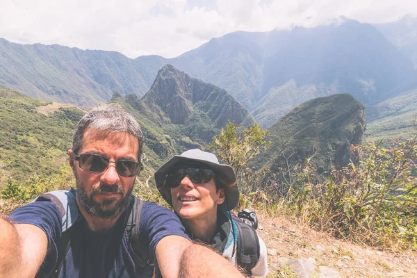 Pareja tomando selfie en las terrazas sobre Machu Picchu, el destino turístico más visitado en Perú. Concepto de aventuras en Sudamérica y personas que viajan alrededor del mundo. Imagen tonificada . — Foto de Stock