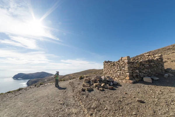 Mochilero explorando los majestuosos Senderos Incas en Isla del Sol, Lago Titicaca, entre los destinos turísticos más pintorescos de Bolivia. Aventuras de viaje y vacaciones en las Américas. Imagen tonificada . — Foto de Stock