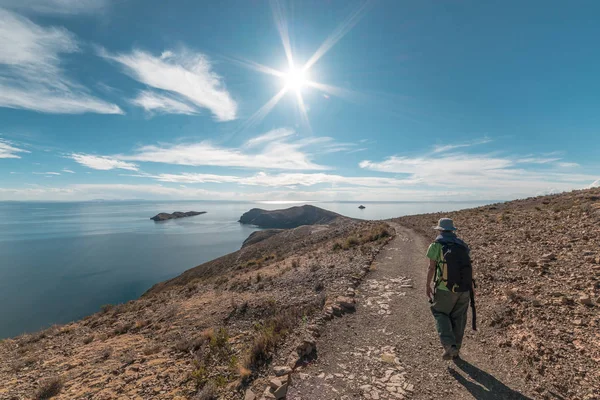 Backpacker explorando as majestosas trilhas incas na Ilha do Sol, Lago Titicaca, entre o destino de viagem mais pitoresco da Bolívia. Aventuras de viagem e férias nas Américas. Imagem tonificada . — Fotografia de Stock