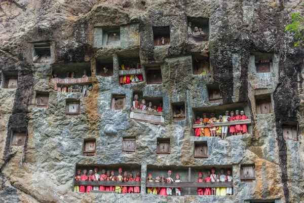 Lemo (Tana Toraja, South Sulawesi, Indonesia), famous burial site with coffins placed in caves carved into the rock, guarded by balconies of dressed wooden statues, images of the dead persons (called — Stock Photo, Image