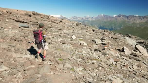 Frau, die in der hoch gelegenen felsigen Berglandschaft wandert. Sommerabenteuer auf den italienischen Alpen. Zeitlupe. — Stockvideo