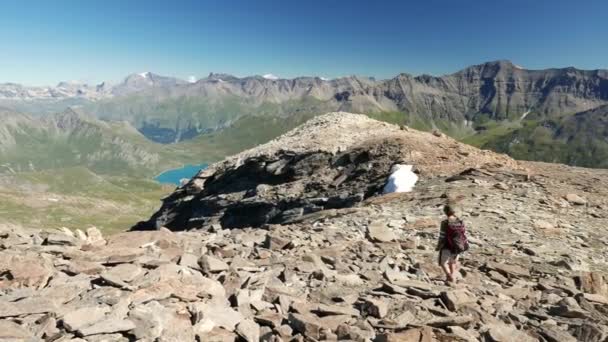 Frau, die in der hoch gelegenen felsigen Berglandschaft wandert. Sommerabenteuer auf den italienischen Alpen. Zeitlupe. — Stockvideo