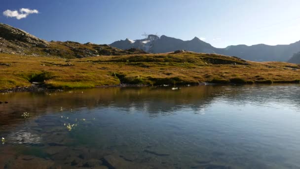 High altitude alpine lake in idyllic landscape once covered by glaciers. Reflection of snowcapped mountain range. Italian Alps, Gran Paradiso National Park. — Stock Video