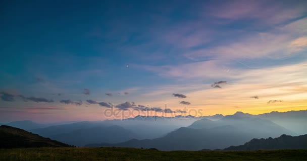 El día a la noche transcurre desde lo alto de los Alpes. Colorido atardecer sobre picos de montaña y niebla en los valles de abajo, nubes en movimiento, luna poniente y estrellas giratorias . — Vídeo de stock