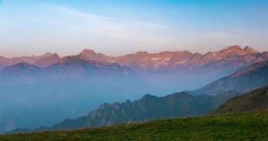 Karlı dağ zirveleri buzul ve yaz Alpler'de, zaman atlamalı, gündoğumu hareketli bulutlar ile.