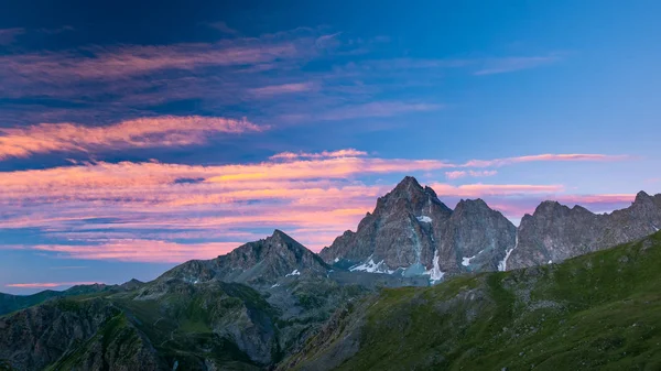 Colorida luz del sol en los majestuosos picos de las montañas y crestas de los Alpes italianos. Niebla y niebla que cubren los valles de abajo, paisaje herboso estéril en primer plano . —  Fotos de Stock