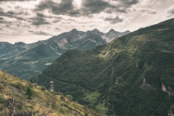 Sunlight on alpine valley with glowing mountain peaks and scenic clouds. Italian French Alps, summer travel destination, toned image, vintage filter, split toning. — Stock Photo, Image