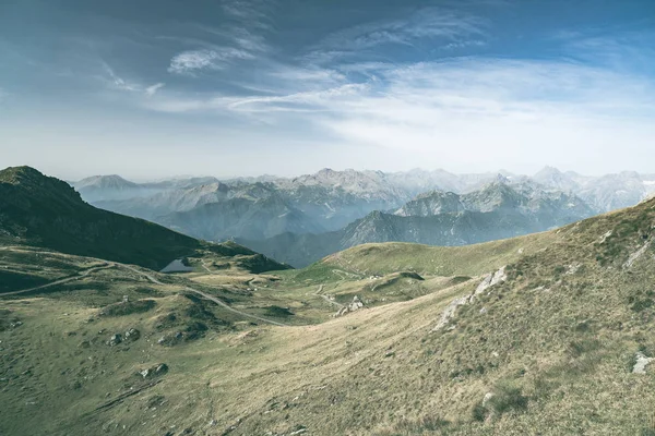 Pascolo d'alta quota, vette rocciose e cresta frastagliata, con cielo panoramico, le Alpi italiane. Vista estesa in retroilluminazione. Immagine desaturata tonica . — Foto Stock