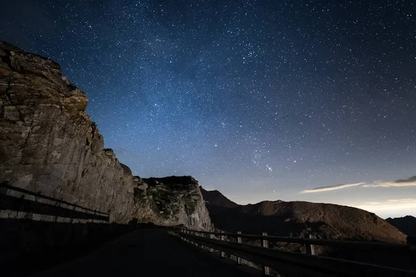 Noche en los Alpes bajo el cielo estrellado y los majestuosos acantilados rocosos en los Alpes italianos, con la constelación de Orión en el horizonte . — Foto de Stock