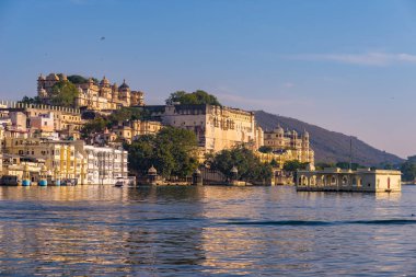 Udaipur cityscape batımında renkli gökyüzü ile. Göl PICHOLA, seyahat hedef, Rajasthan Hindistan görkemli şehir sarayının