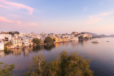 Udaipur cityscape batımında renkli gökyüzü ile. Göl PICHOLA, seyahat hedef, Rajasthan Hindistan görkemli şehir sarayının
