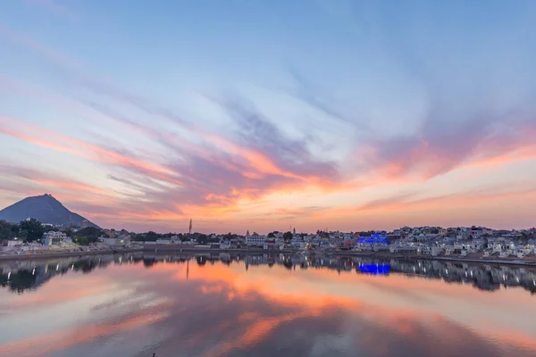 Colorful sky and clouds over Pushkar, Rajasthan, India. Temples, buildings and colors reflecting on the holy water of the lake at sunset. — Stock Photo, Image