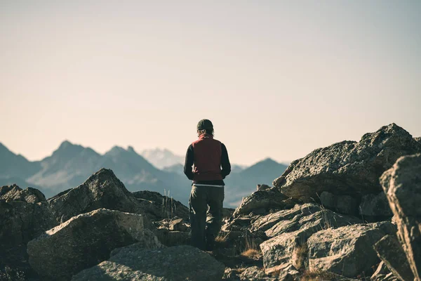 Hiker in high altitude rocky mountain landscape. Summer adventures on the Italian French Alps, toned image. — Stock Photo, Image