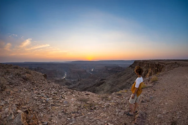 Balık River Canyon, doğal seyahat hedef Güney Namibya bakarak turist. Ultra geniş açı görünümü yukarıdan, renkli doğal günbatımı. — Stok fotoğraf