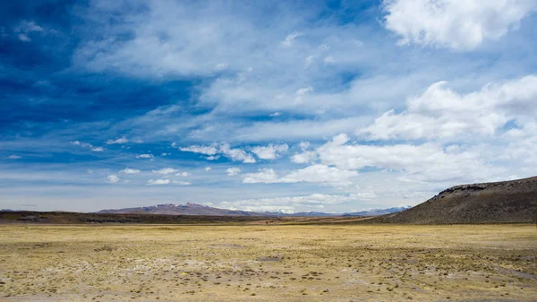 Hochgebirgslandschaft mit rauer karger Landschaft und landschaftlich dramatischem Himmel. Weitwinkelblick von oben auf 4000 m über das Hochland der Anden, Peru. — Stockfoto