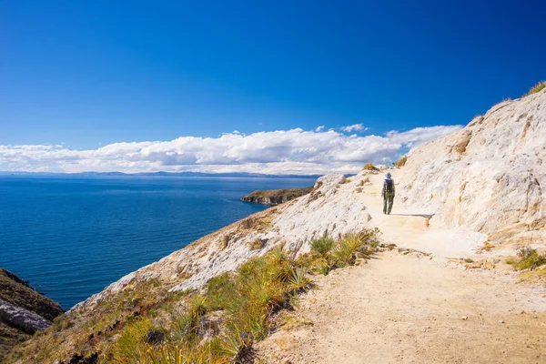 Backpacker explorando as majestosas trilhas incas na Ilha do Sol, Lago Titicaca, entre o destino de viagem mais pitoresco da Bolívia. Aventuras de viagem e férias nas Américas. Imagem tonificada . — Fotografia de Stock