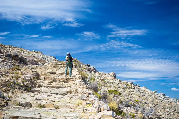 Mochilero explorando los majestuosos Senderos Incas en Isla del Sol, Lago Titicaca, entre los destinos turísticos más pintorescos de Bolivia. Aventuras de viaje y vacaciones en las Américas. Imagen tonificada . — Foto de Stock