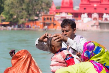 Harid, Hindistan - 20 Mart 2017: kıllar Haridwar, Hindistan Ganj nehir üzerinde genç Hindu devotee başlatılması için kapalı tıraş dostum.