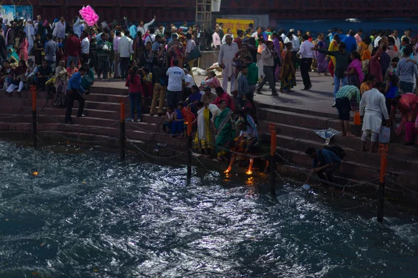 Haridwar, India - 20 de marzo de 2017: Santos ghats en Haridwar, India, ciudad sagrada para la religión hindú. Peregrinos ofreciendo flores flotantes y velas encendidas al río Ganges . — Foto de Stock
