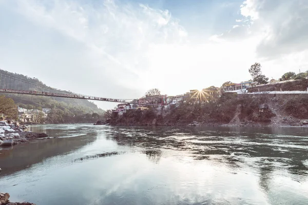 Paisaje urbano de Rishikesh al atardecer, ciudad santa en el río Ganges y popular destino de viaje hipster en la India. Imagen tonificada, luz del sol reventada . —  Fotos de Stock