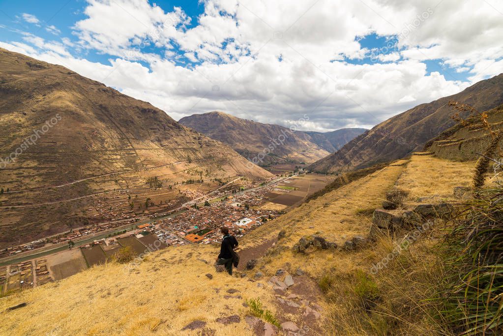 Tourist exploring the Inca Trails and the majestic terraces of Pisac, Sacred Valley, major travel destination in Cusco region, Peru. Vacations and adventures in South America.