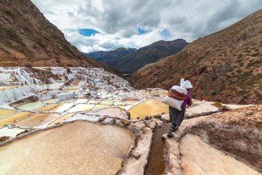 Tuz, Maraş, Urubamba Vadisi, Peru teraslı tuz tavalarda üzerinde büyük bir çuval taşıma işçisi. Gelişmekte olan ülkelerde manuel çalışma. Tanınmayan kişi arka görünüm.