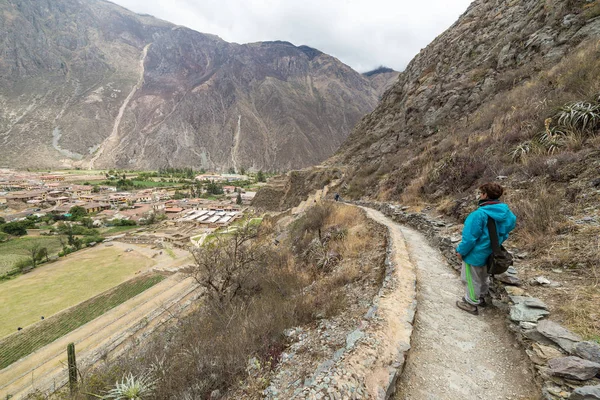 Turista que explora as trilhas incas e o sítio arqueológico em Ollantaytambo, Vale Sagrado, destino de viagem na região de Cusco, Peru. Férias e aventuras na América do Sul . — Fotografia de Stock