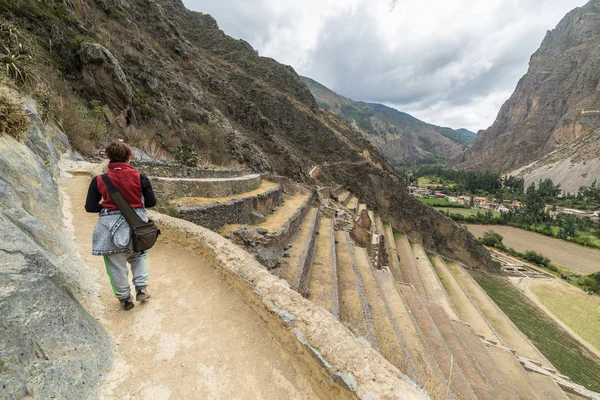 Turista explorando los Senderos Incas y el sitio arqueológico en Ollantaytambo, Valle Sagrado, destino turístico en la región del Cusco, Perú. Vacaciones y aventuras en Sudamérica . — Foto de Stock