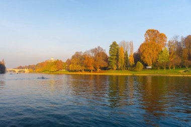 Torino (Turin - İtalya) şehir görünümünü Po Nehri ve renkli ağaçlar bakan tepenin üzerinde kilise ile Sonbahar sezonu gün batımında. Açık gökyüzü ve sıcak güneş ışığı.