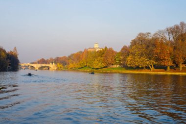 Torino (Turin - İtalya) şehir görünümünü Po Nehri ve renkli ağaçlar bakan tepenin üzerinde kilise ile Sonbahar sezonu gün batımında. Açık gökyüzü ve sıcak güneş ışığı.