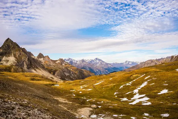 Panoramic view of valley and mountain range in a colorful autumn with yellow meadows and high mountain peaks in the background. Wide angle shot in the Italian French Alps. — Stock Photo, Image