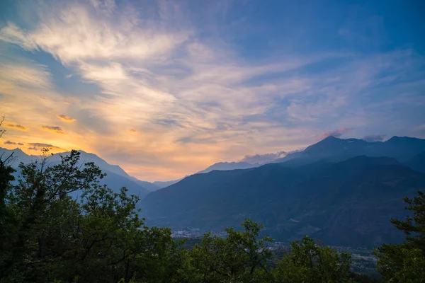 在日落时意大利的阿尔卑斯山。夏天五颜六色上空雄伟的山峰、 林地和绿色的山谷. — 图库照片