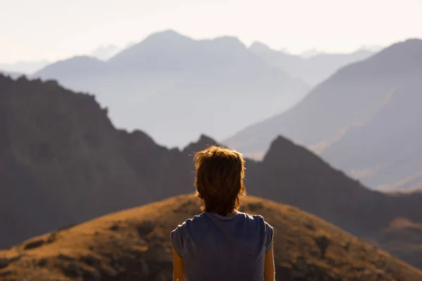 Uma pessoa a olhar para a vista no alto dos Alpes. Paisagem extrovertida, vista idílica ao pôr-do-sol. Vista traseira . — Fotografia de Stock