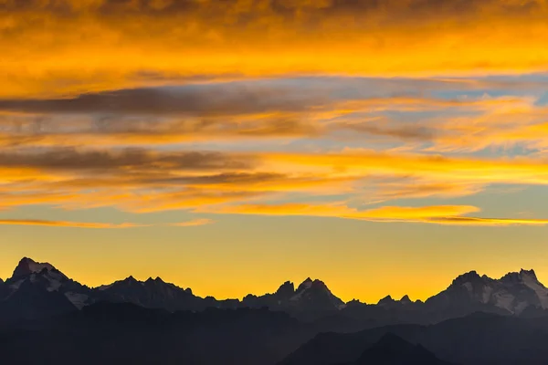 翻过了阿尔卑斯山的日落。色彩斑斓的天空，高海拔山峰和冰川，地块 des 埃国家公园，法国。遥远的长焦视图. — 图库照片