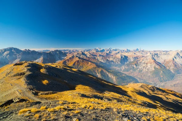 Nascer do sol sobre os Alpes, o Maciço des Ecrins (4101 m) parque nacional com geleiras, França. Céu azul claro, cores de outono, vista expansiva de Bardonecchia, Itália . — Fotografia de Stock