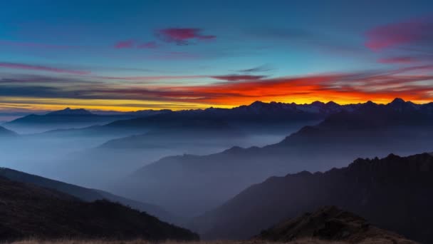 Panorama en los Alpes al atardecer. Impresionante cielo colorido, picos de montaña de gran altitud, niebla en los valles . — Vídeos de Stock