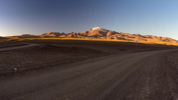 O Panorama dos Andes ao pôr-do-sol, viagem entre a Bolívia e o Chile. Estrada 4x4 nas montanhas andinas desertas com pico de montanha coberto de neve, Bolívia . — Vídeo de Stock