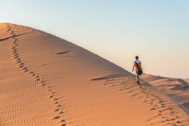Sossusvlei, Namib Çölü, Namib Naukluft Milli Parkı, Namibya, kum tepeleri üzerinde yürüyen turist. Afrika'da kişi, macera ve tatil seyahat.