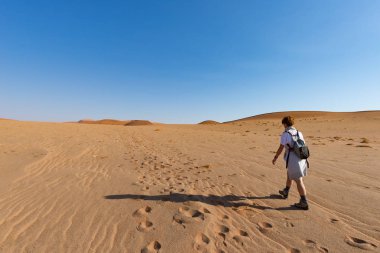 Sossusvlei, Namib Çölü, Namib Naukluft Milli Parkı, Namibya, kum tepeleri üzerinde yürüyen turist. Afrika'da kişi, macera ve tatil seyahat.