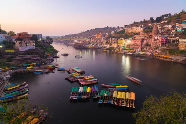 Paisaje urbano de Omkareshwar al atardecer, India, templo hindú sagrado. Río Santo Narmada, barcos flotando. Destino turístico para turistas y peregrinos . —  Fotos de Stock