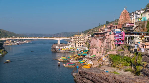 Omkareshwar paisaje urbano, India, templo hindú sagrado. Río Santo Narmada, barcos flotando. Destino turístico para turistas y peregrinos . —  Fotos de Stock