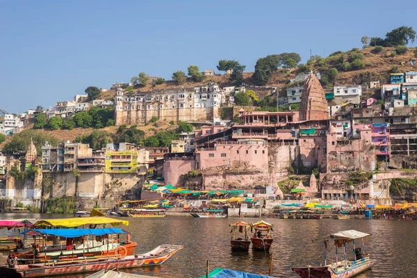 Omkareshwar paisaje urbano, India, templo hindú sagrado. Río Santo Narmada, barcos flotando. Destino turístico para turistas y peregrinos . — Foto de Stock