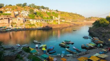 Günbatımı zaman atlamalı Omkareshwar cityscape, Hindistan, kutsal hindu Tapınağı. Kutsal Narmada nehir, yüzen tekne. Turistler ve hacılar için seyahat hedef.