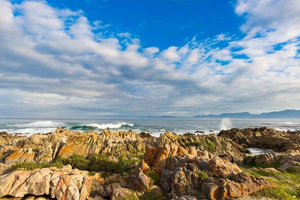 Skalnaté pobřeží linka na oceánu na De Kelders, Jižní Afrika, proslulá velryb. Zimní sezóna, zataženo a dramatická obloha. — Stock fotografie