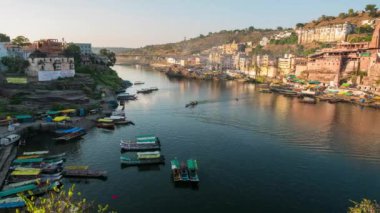 Günbatımı zaman atlamalı Omkareshwar cityscape, Hindistan, kutsal hindu Tapınağı. Kutsal Narmada nehir, yüzen tekne. Turistler ve hacılar için seyahat hedef.