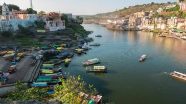 Günbatımı zaman atlamalı Omkareshwar cityscape, Hindistan, kutsal hindu Tapınağı. Kutsal Narmada nehir, yüzen tekne. Turistler ve hacılar için seyahat hedef.