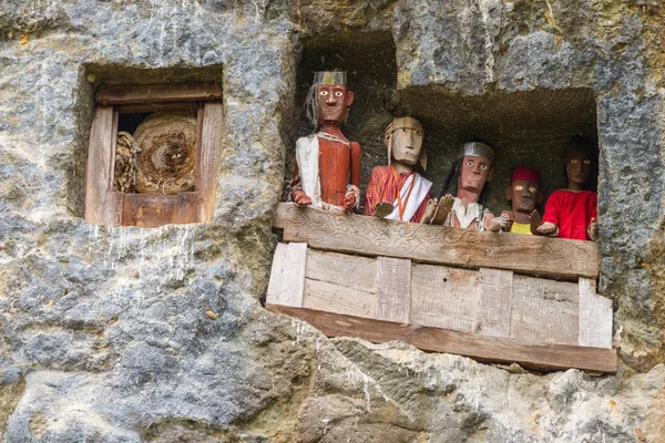 Lemo, Indonesia - september 5, 2014: famous burial site with coffins placed in caves carved into the rock, guarded by the statues of the dead persons (called tau tau in local language). Tana Toraja, S — Stock Photo, Image