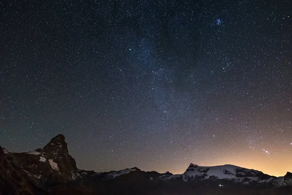 Underbar stjärnhimmel över bergstoppen Matterhorn (Cervino) och Monte Rosa glaciärer, berömda skidorten i Aostadalen, Italien. Andromedagalaxen tydligt synlig mitten av ram. — Stockfoto