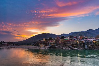 Rishikesh, kutsal şehir anda alacakaranlıkta ve hedef Hindistan'da seyahat. Renkli gökyüzü ve bulutlar Ganj Nehri üzerinde yansıtan. 