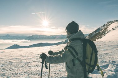 Alpler üzerinde yüksek rütbeli manzaraya bakarak Polonyalılar hiking ile kadın backpacker. Görünümü, kış soğuk kar arka, arka ışık yıldızı güneş, bölünmüş tonlama, doygunluğu azaltılmış.